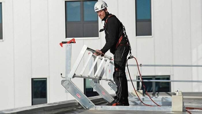 Image showing a roof worker unfolding an ABS Mobile Guard - flat guard rail