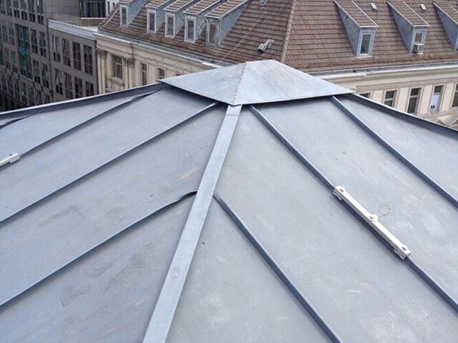 Foto eines montierten Dach-Sekuranten mit Spezialklemmen für Rundbördel.Photo d’un point d’ancrage sur toiture monté avec des mâchoires spéciales pour joints arrondis