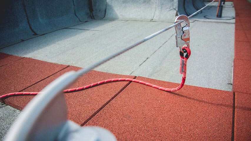 Photo de l’utilisation d’un connecteur dont le mousqueton est attaché à une ligne de vie
